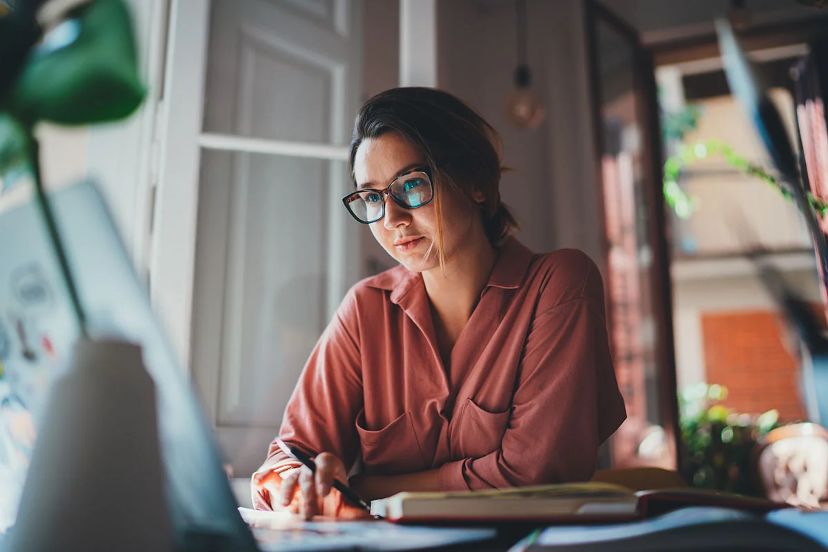 Pretty young woman an advertising copywriter in eyeglasses worki